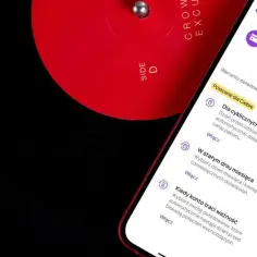 Aplikacja mobilna pokazuje opcje jak doładować Play, obok czerwonej płyty winylowej.